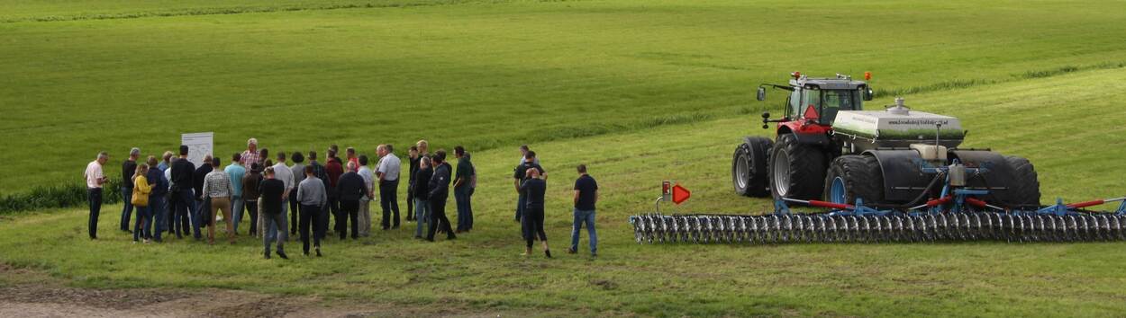 Groep mensen in een weiland bij een precisiebemester