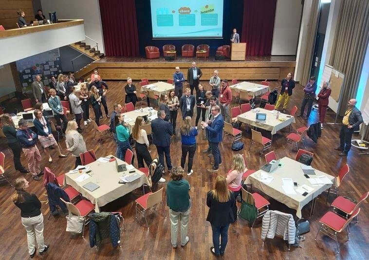 groep mensen staand in grote vergaderzaal