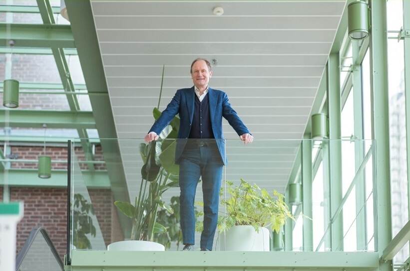 Henk Reinen achter balustrade van glas