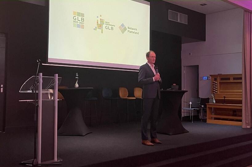 Henk Reinen op podium met presentatie nieuwe logo's Regieorganisatie GLB