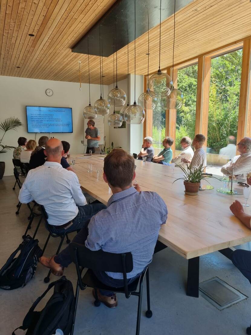 mensen aan vergadertafel kijkend naar presentatiescherm